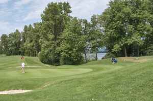 Green du golf de Miribel-Jonage, drapeau et lac en arrière-plan